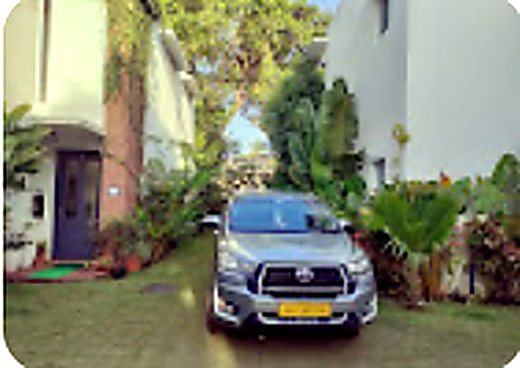 Cab parked in lush tropical Goa driveway in Vagator